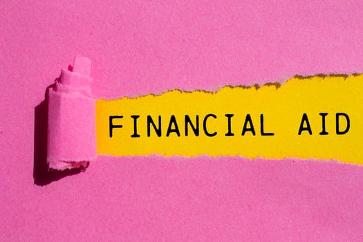 Financial aid message written on ripped torn pink paper with yellow background. Conceptual financial aid symbol. Copy space. photo