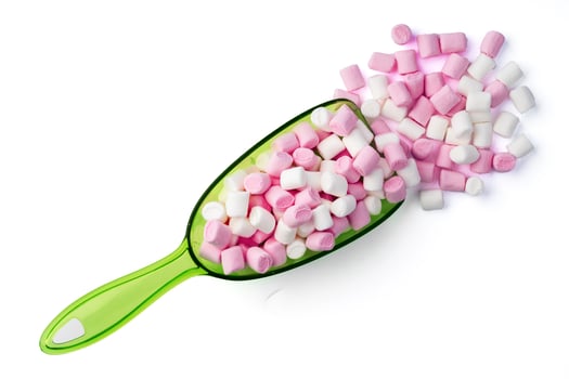 Mini marshmallows in plastic scoop on white background photo