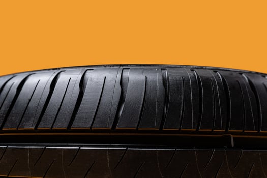 Car tires isolated on yellow background, close up photo