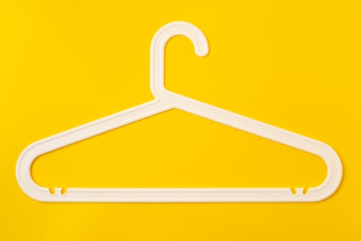 Hanger on colored paper background. Minimalistic fashion concept. photo