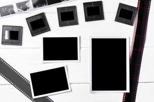 Old vintage film, slides and photos on white wooden background