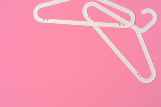 Flat lay composition with empty hangers on pink background photo
