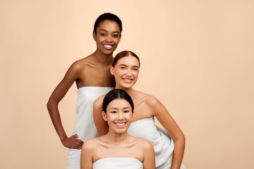 Three Multicultural Women In Bath Towels Posing In Studio On White Background. Female Group Beauty Portrait photo