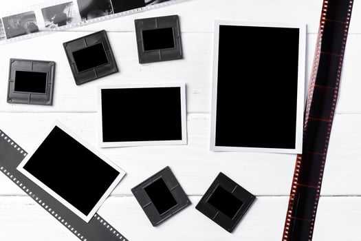 Old vintage film, slides and photos on white wooden background