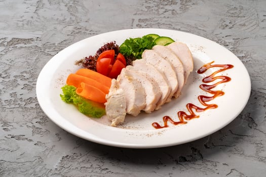 Roast chicken fillets and vegetables on gray background photo