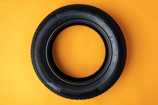Car tires isolated on yellow background, close up photo