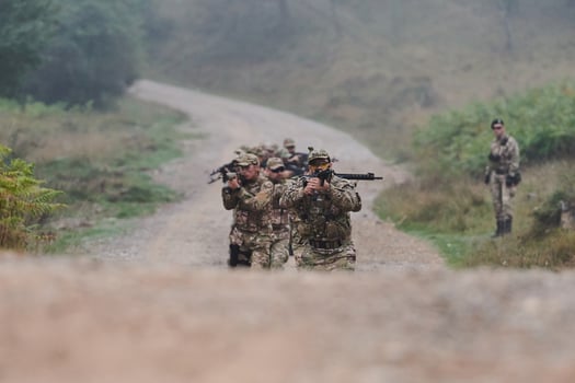 A disciplined and specialized military unit, donned in camouflage, strategically patrolling and maintaining control in a high-stakes environment, showcasing their precision, unity, and readiness for photo
