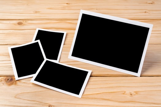 Blank photo frames for your photos on wooden background