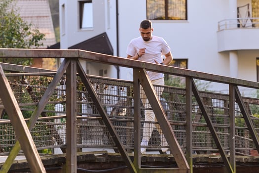 A handsome man maintains his healthy lifestyle as he runs along beautiful natural trails, embodying the essence of fitness, wellness, and vitality in the midst of scenic outdoor surroundings. photo