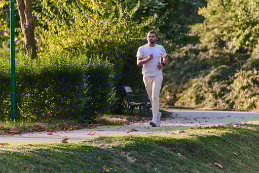 A handsome man maintains his healthy lifestyle as he runs along beautiful natural trails, embodying the essence of fitness, wellness, and vitality in the midst of scenic outdoor surroundings. photo