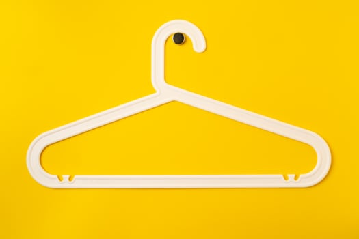 Hanger on colored paper background. Minimalistic fashion concept. photo