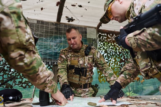 A highly trained military unit strategizes and organizes a tactical mission while studying a military map during a briefing session photo