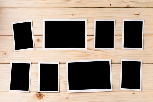 Blank photo frames for your photos on wooden background