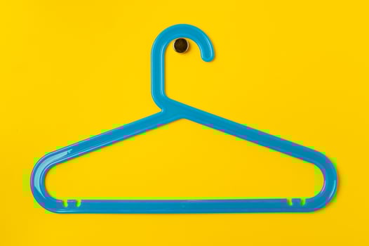 Hanger on colored paper background. Minimalistic fashion concept. photo