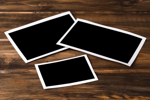 Blank photo frames for your photos on wooden background