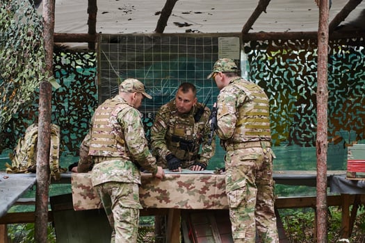A highly trained military unit strategizes and organizes a tactical mission while studying a military map during a briefing session photo