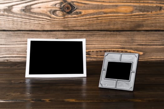 Blank photo frame on brown wooden background