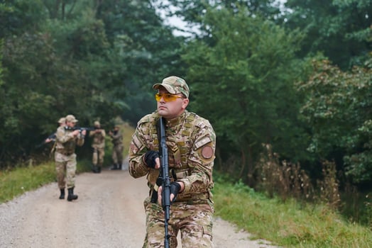 A disciplined and specialized military unit, donned in camouflage, strategically patrolling and maintaining control in a high-stakes environment, showcasing their precision, unity, and readiness for photo
