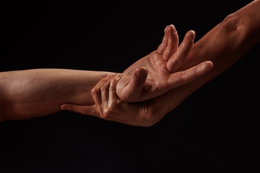 girl masseur doing hand massage to man on dark background close-up, beautiful relaxation massage photo