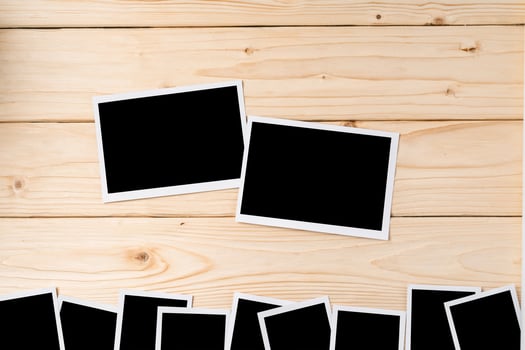 Blank photo frames for your photos on wooden background