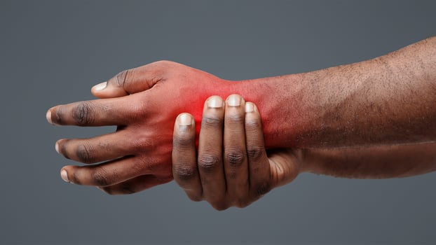 Close up of afro man suffering from rheumatism, massaging his wrist over white background photo