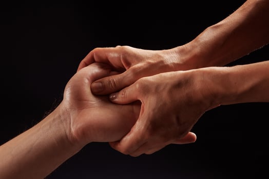 girl masseur doing hand massage to man on dark background close-up, beautiful relaxation massage photo