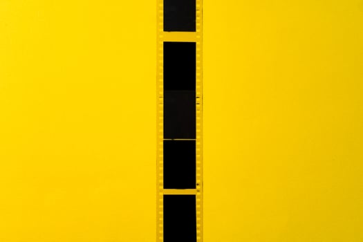 Old vintage film for a camera on yellow background photo