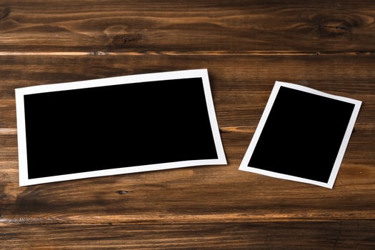 Blank photo frames for your photos on wooden background