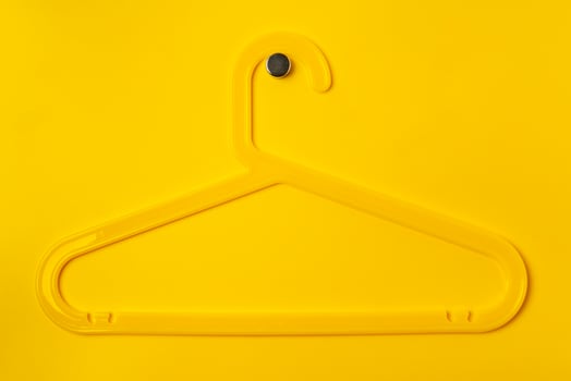 Hanger on colored paper background. Minimalistic fashion concept. photo