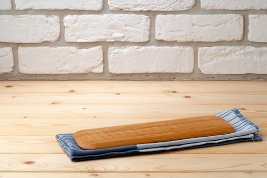 Cutting board with cotton napkin on wooden table photo