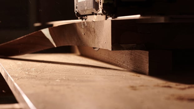 Carpenter using circular saw for cutting wooden plank. Man worker building wooden frame. Carpentry tools in use. Cutting a piece of wood in furniture factory. photo