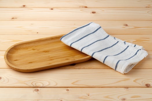 Cutting board with cotton napkin on wooden table photo