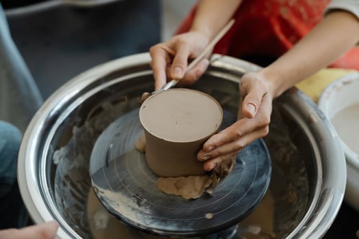 Creating pottery on a wheel in an art studio during daylight hours photo