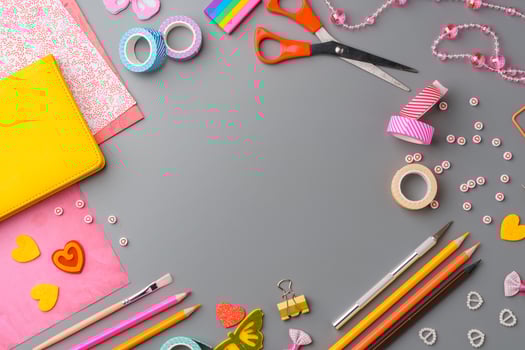 Crafting supplies arranged for a DIY project on a gray table with scissors, washi tape, and decorative items photo