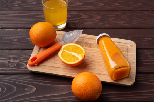 Fresh orange juice in the glass with orange fruit on wooden background photo