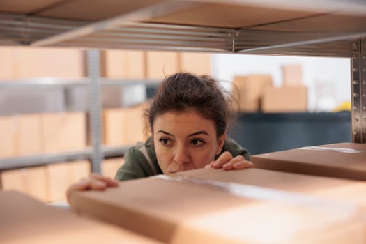 Selective focus of supervisor standing in delivery service storage, preparing customers online orders. Stockroom manager wearing industrial overall while working and coordinating goods supply chain photo