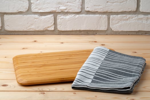 Cutting board with cotton napkin on wooden table photo