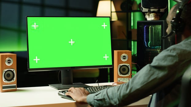 Gamer using headphones to discuss with mates while playing online videogame on isolated screen monitor. Man enjoying coop game with friends on mockup computer display, chatting on internet photo