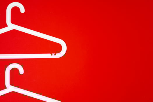 Hanger on red paper background. Minimalistic fashion concept. Top view photo