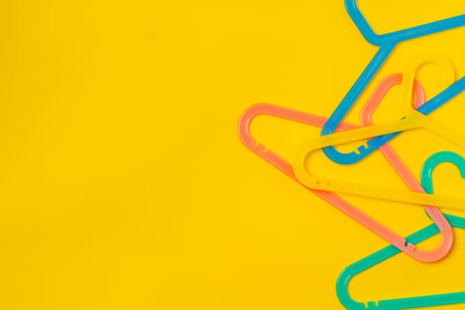Hanger on colored paper background. Minimalistic fashion concept. photo