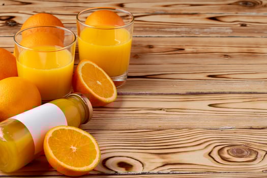 Orange fruit and orange juice on wooden background photo