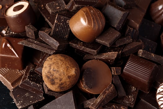Chocolate candies and chocolate pieces pile for background photo