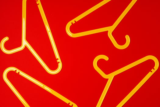 Hanger on red paper background. Minimalistic fashion concept. Top view photo