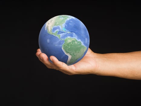 Senior man holding the Earth in his hand. Concept of saving the Earth, environment, and energy. photo