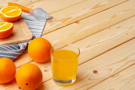 Glass of fresh orange juice with fresh fruits on wooden table photo