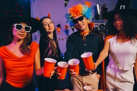 Joyful office Halloween party with coworkers in costumes, celebrating with drinks and laughter, fostering teamwork and festive spirit photo