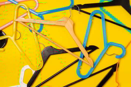 Hanger on colored paper background. Minimalistic fashion concept. photo