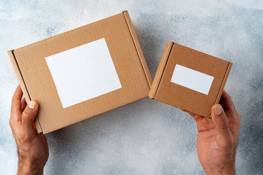 Parcel cardboard box in a man hands on a gray table background photo