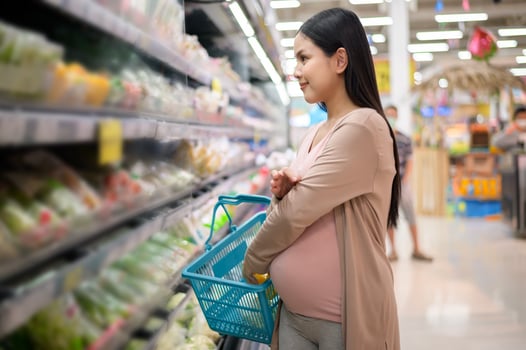 Beautiful pregnant woman shopping healthy food at grocery shop photo