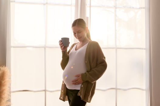 Portrait of Beautiful pregnant woman holding cup photo